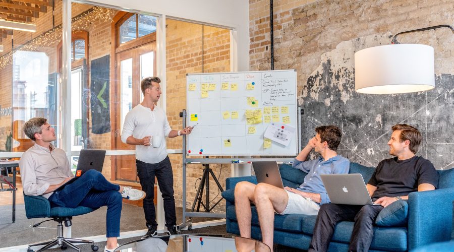 A group of young men sitting around a whiteboard