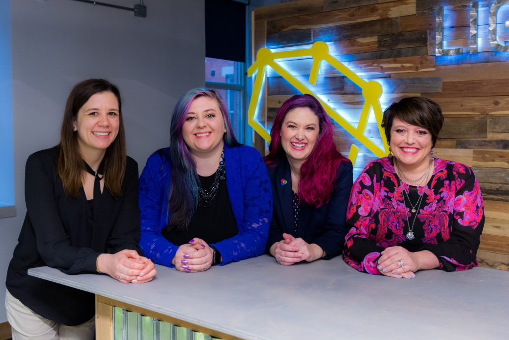 4 Woman are sitting and smiling at the camera