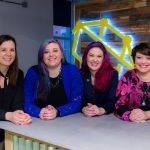 4 Woman are sitting and smiling at the camera