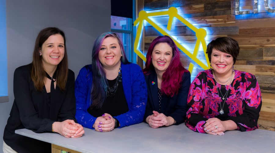 4 Woman are sitting and smiling at the camera