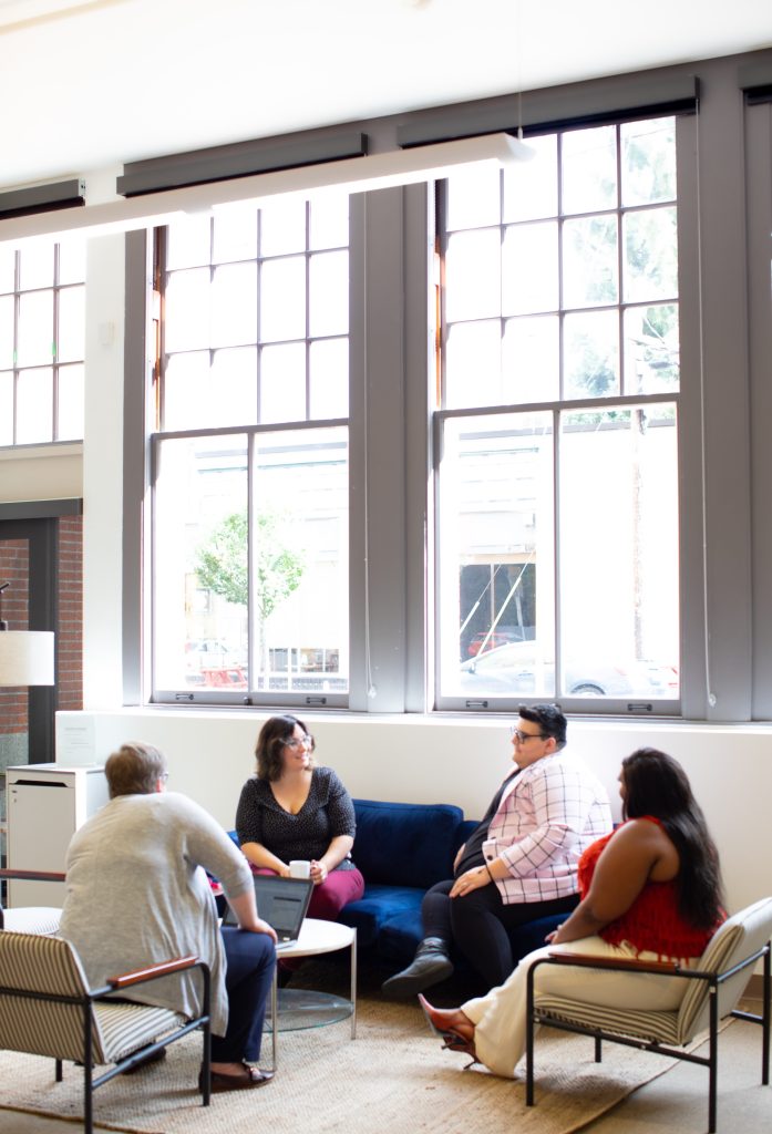 A group of people are sitting in an office environment