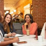 A group mod business woman are sitting at a table talking