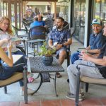 A group of men and woman are sitting and talking