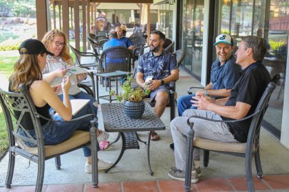 A group of men and woman are sitting and talking