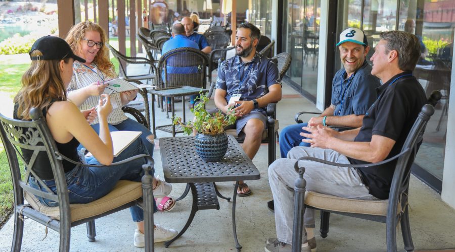 A group of men and woman are sitting and talking